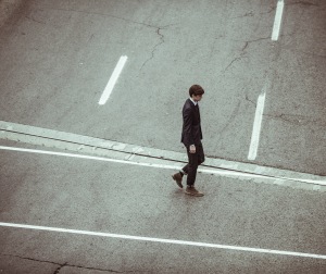 Man crosses the road after help from enhance coaching to take control, be successful and move career forward